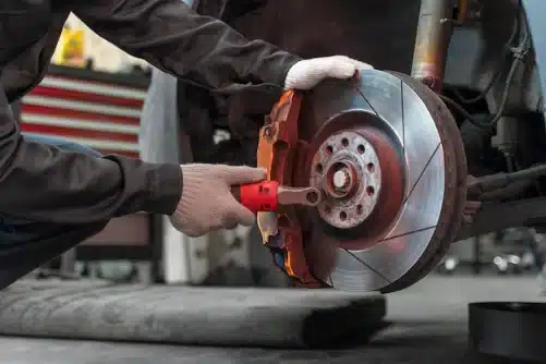 Mobile car maintenance service performing brake repair on vehicle