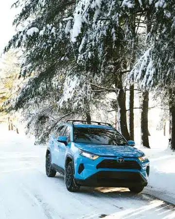 Toyota RAV4 blue SUV driving through snow – Mobile Toyota oil change services for all seasons