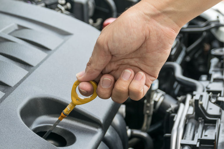 A Hand Checking the Oil Level