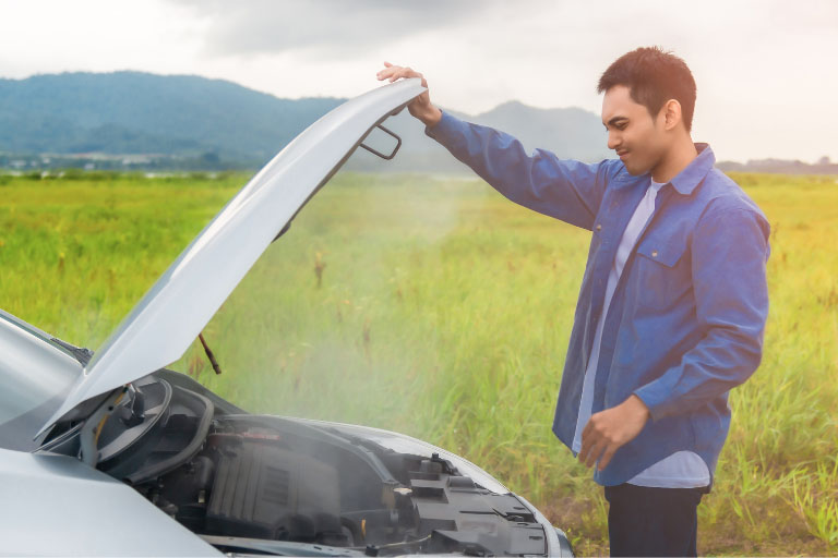 A Man Inspecting a Overheated Car Engine