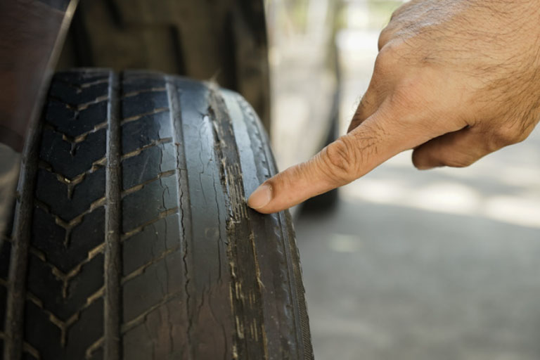 A Mechanic Showing a Uneven Tire Wear