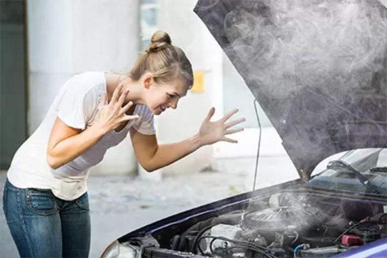 A Women Checking the White Engine Smoke
