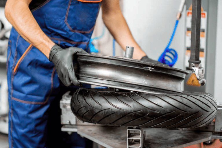 Auto Mechanic Mounting a New Tire onto the Wheel Rim