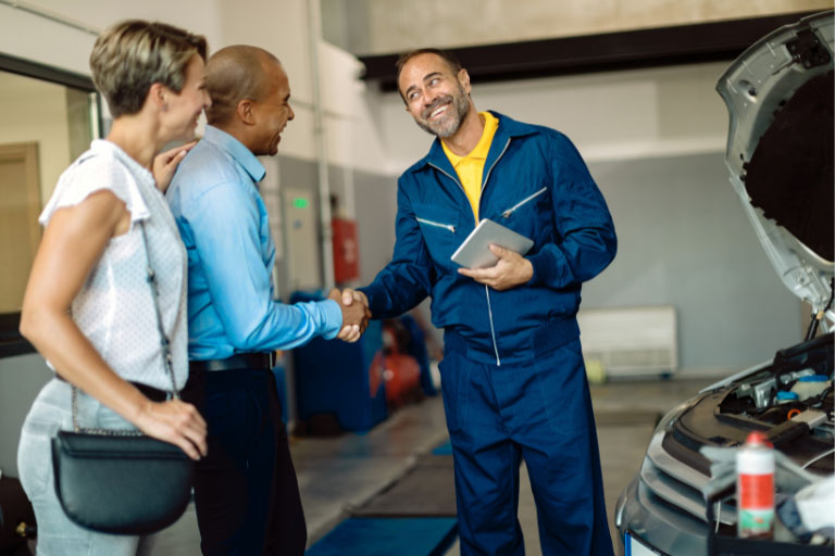 Customers Shaking Hands With an Auto Mechanic at the Repair Shop