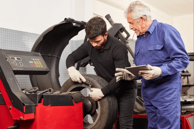 Two Mechanics Checking Mounted Tires for Proper Balance