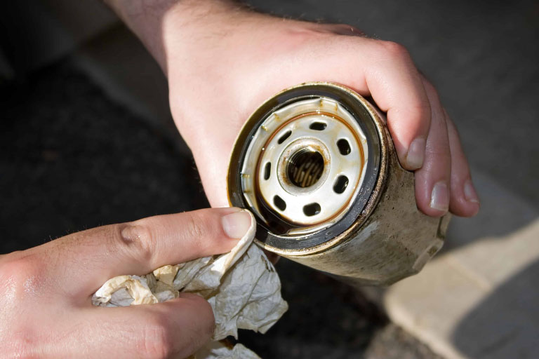 Choosing the Right Oil Filter: A Guide for Car Owners 3 A Mechanic Cleaning Oil From an Engine Oil Filter
