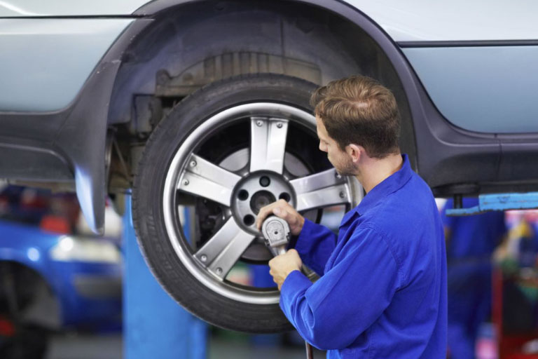 How Much Does a Wheel Alignment Cost in 2025? 3 A Mechanic Installing New Tire on a Vehicle