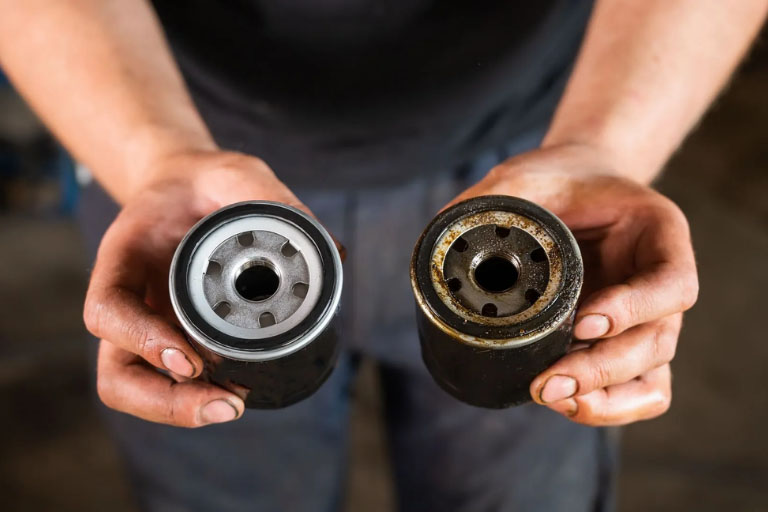 Choosing the Right Oil Filter: A Guide for Car Owners 4 Mechanic Showing Clean vs. Dirty Oil Filters