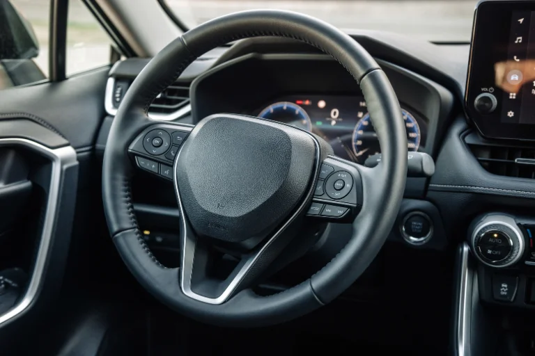 The Difference Between Front-End Alignment and Four-Wheel Alignment 3 Close-up of Off-Center Steering Wheel in a Moving Car