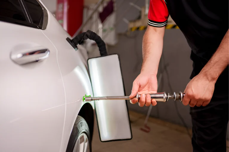How to Fix Car Dents Without Repainting the Whole Panel 3 A Technician Using Paintless Dent Repair Tools on a Car