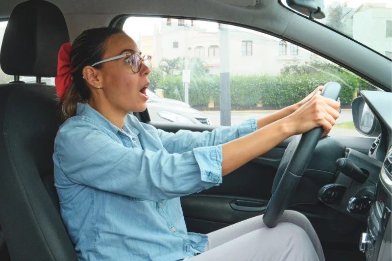 Close-up of a Woman Braking Suddenly while Driving on a Road