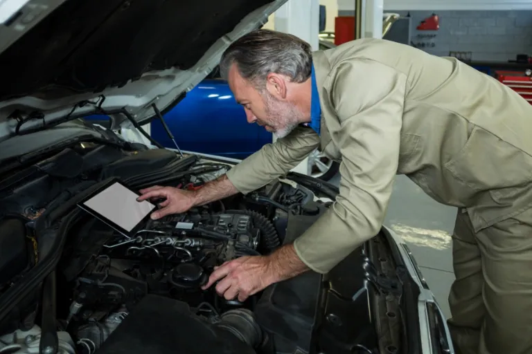 A Technician Inspecting an Engine with a Portable Diagnostic Tool