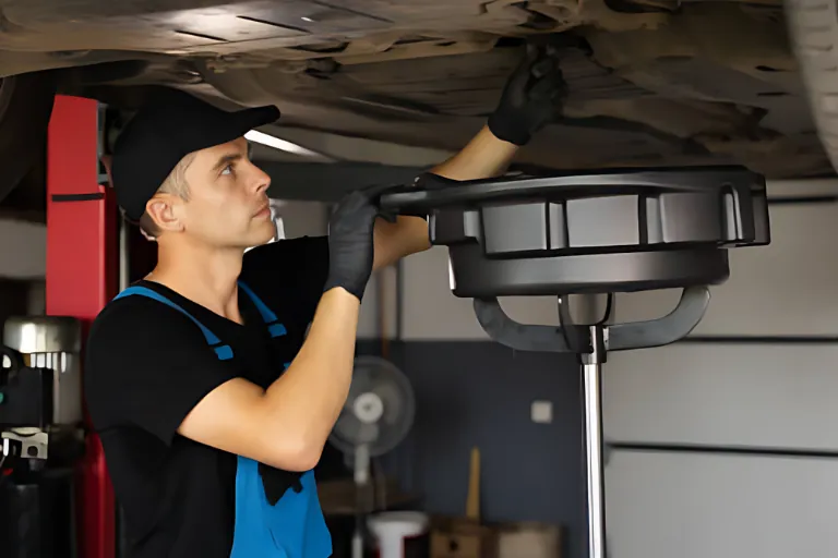 Mobile Oil Change Houston — We Come to You 2 A Technician is Draining Old Engine Oil into a Portable Container