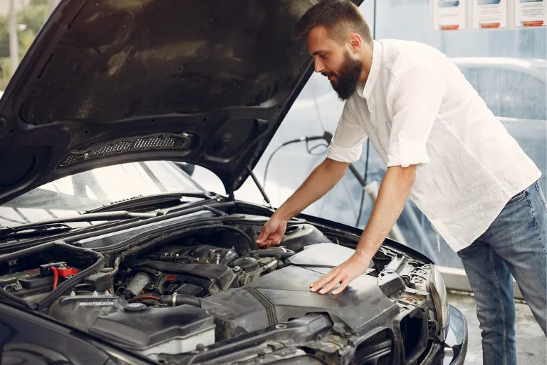 A Close-Up of the Man Checking the Overheated Car Engine