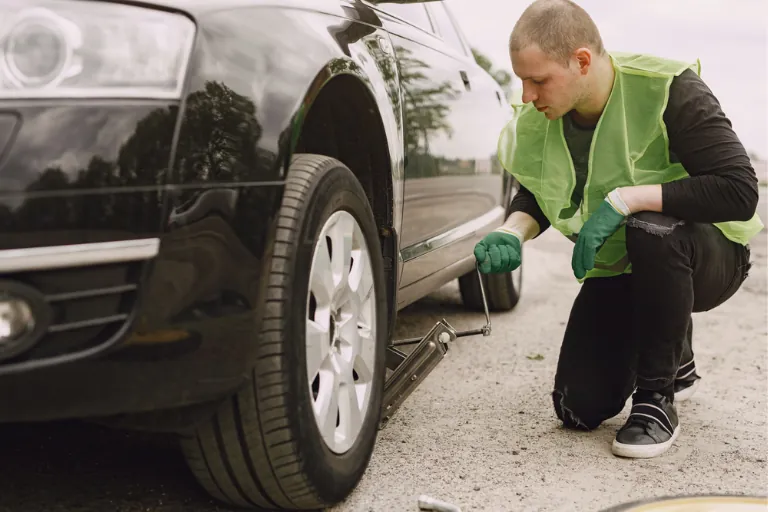 A Mechanic Checking the Tire Pressure of a Car on Texas Roads