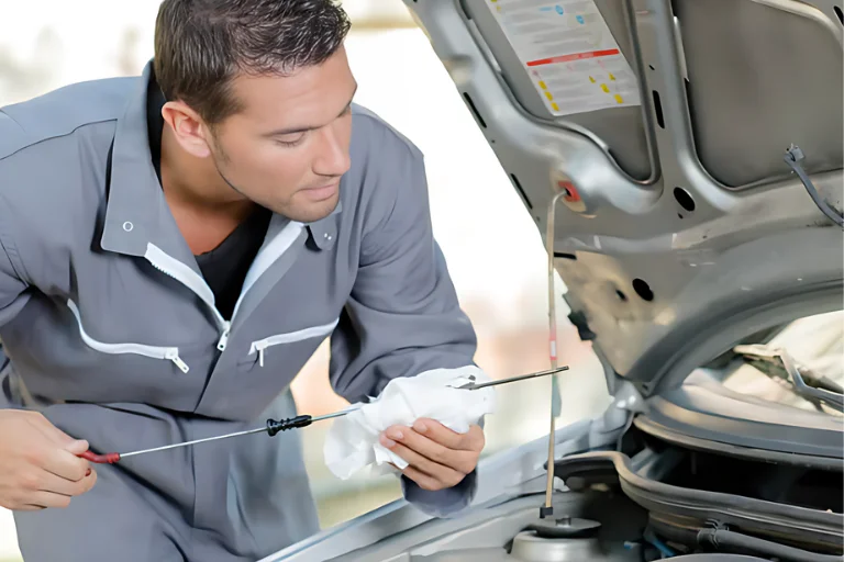 A Technician Checking the Engine Oil During Winter Car Maintenance Massachusetts