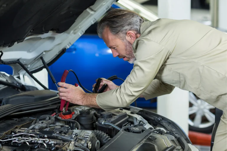 A Technician Inspecting a Car Battery During Winter Car Maintenance