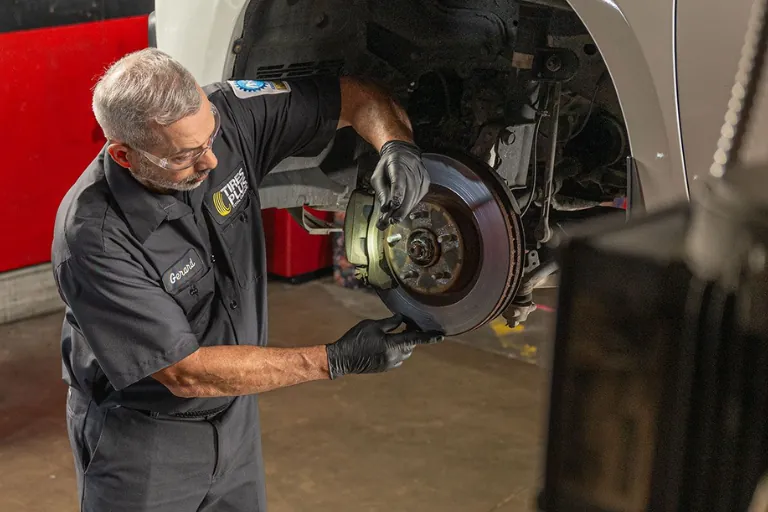A Mechanic Inspecting the Brakes of a Vehicle