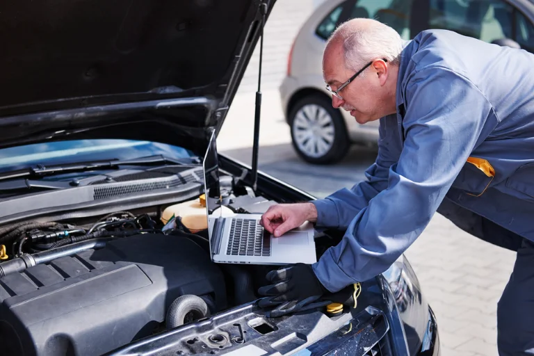 A Technician Inspecting a Vehicle Engine Using a Diagnostic Tool
