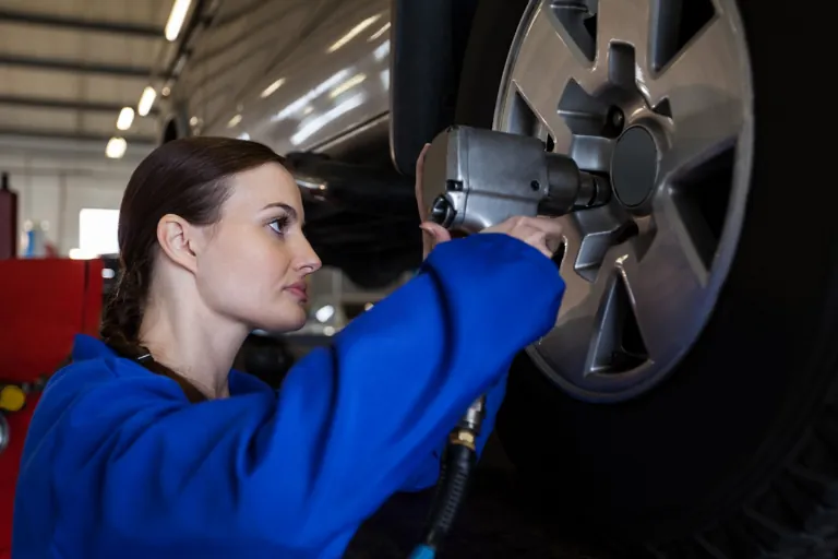 A Mechanic Using a Tire Pressure Gauge to Check Pressure