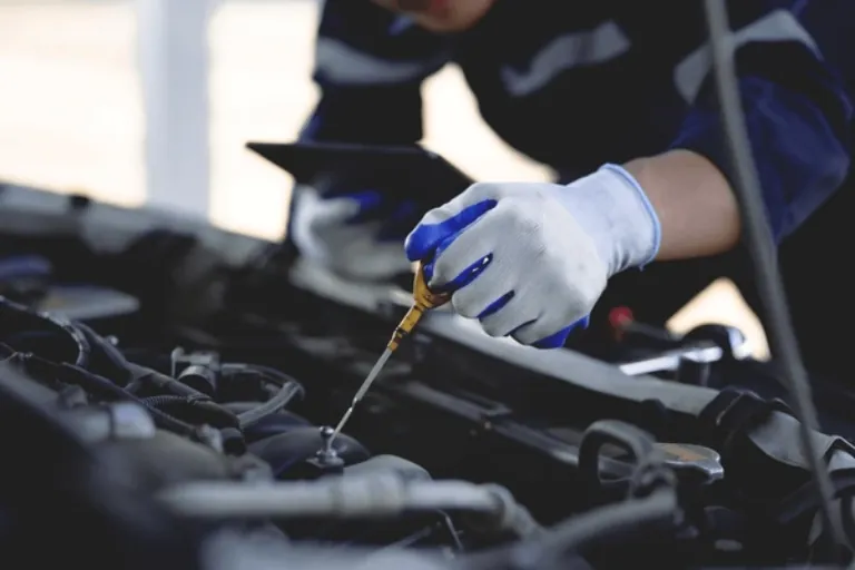 Dirty Engine Oil Being Inspected by a Technician