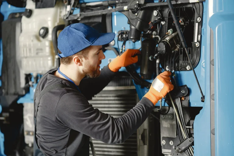 Mechanic inspecting an engine compartment of a fleet truck