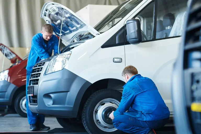 Mobile mechanics performing routine maintenance on a work van