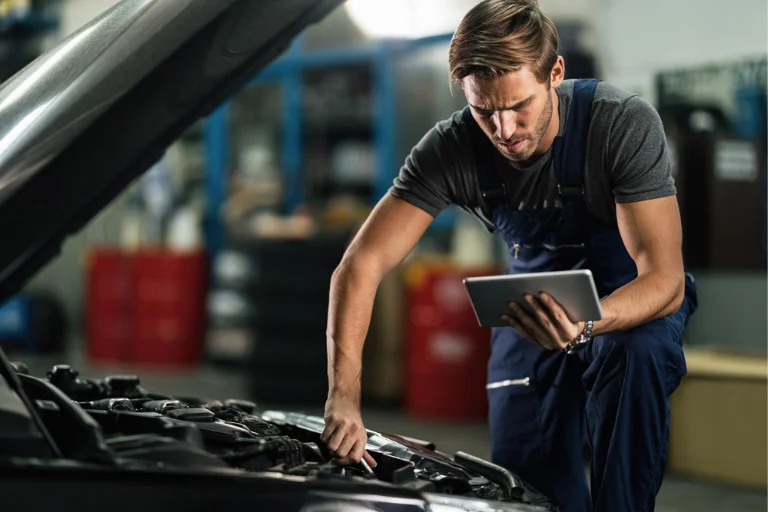 Technician using a maintenance checklist while inspecting a fleet vehicle